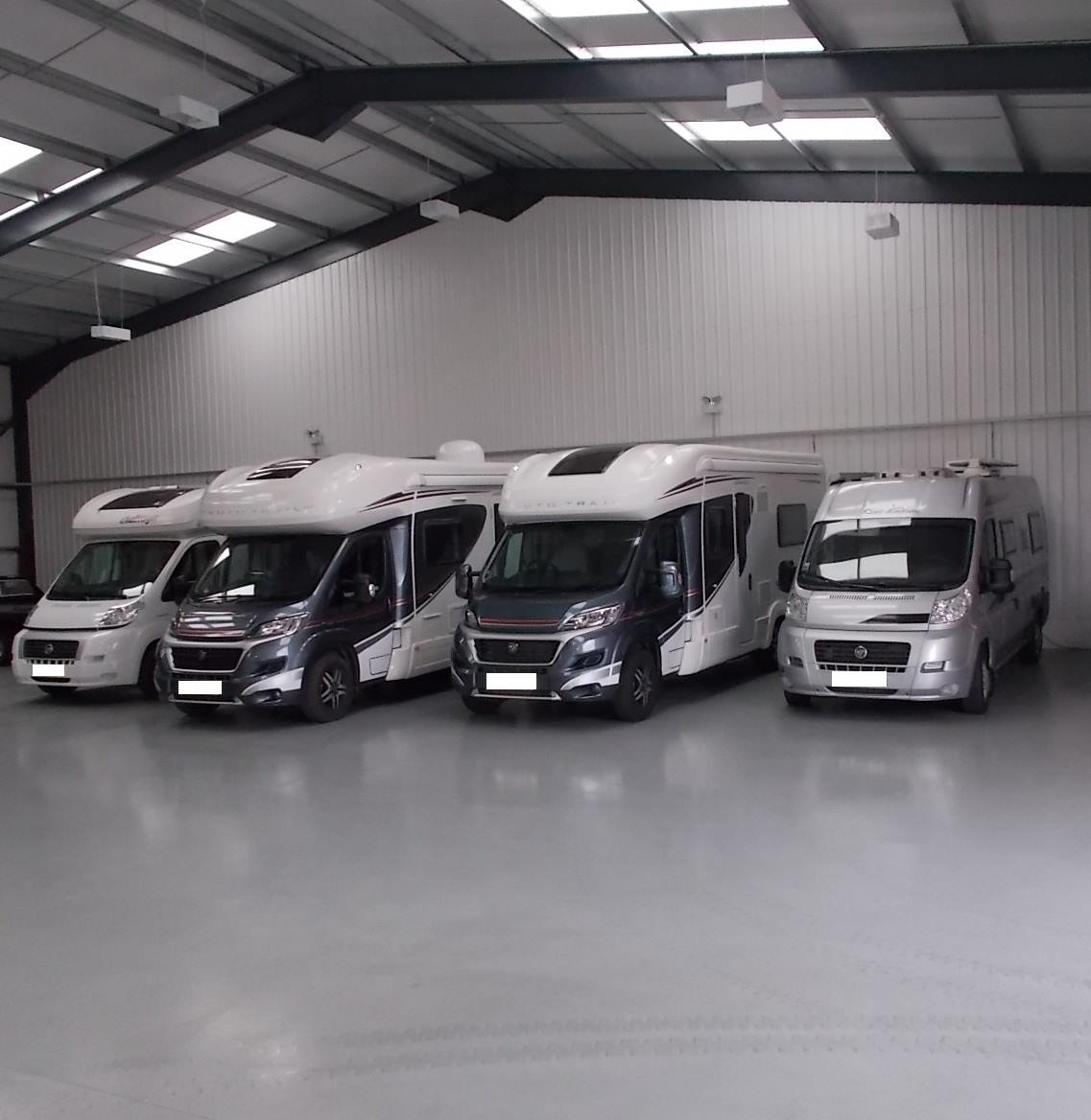 Four motorhomes parked in the clean indoor storage unit at W Sanders & Sons